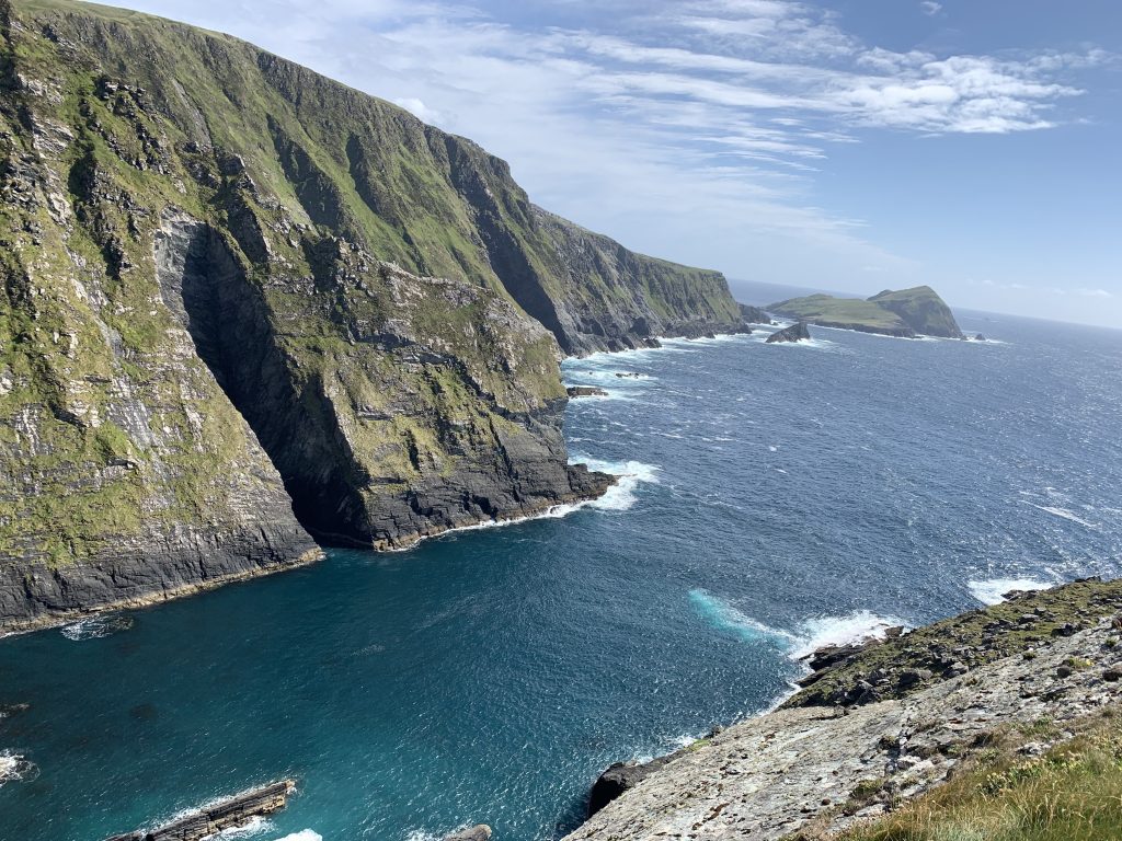Kerry Cliffs with Atlantic Ocean and Skellig Islands in the distance.
